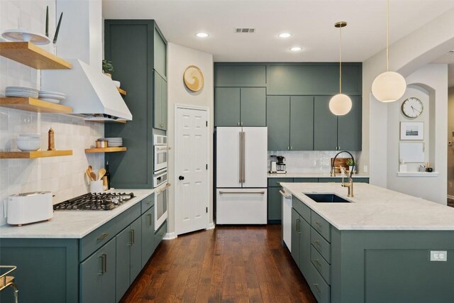 kitchen featuring sink, high end fridge, hanging light fixtures, dark hardwood / wood-style flooring, and stainless steel gas stovetop