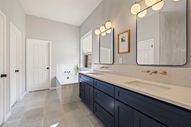 bathroom with a relaxing tiled tub, tile patterned floors, and vanity