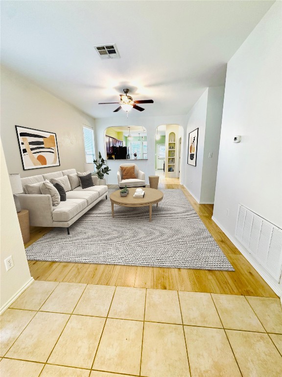 living room with light hardwood / wood-style flooring and ceiling fan