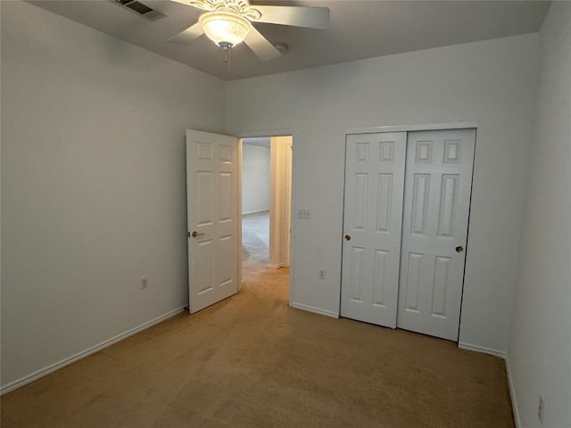 unfurnished bedroom with a closet, ceiling fan, and light carpet