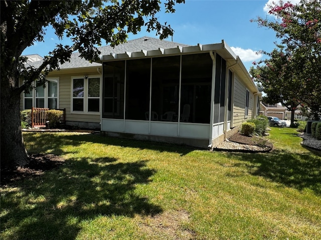 back of house featuring a sunroom and a yard