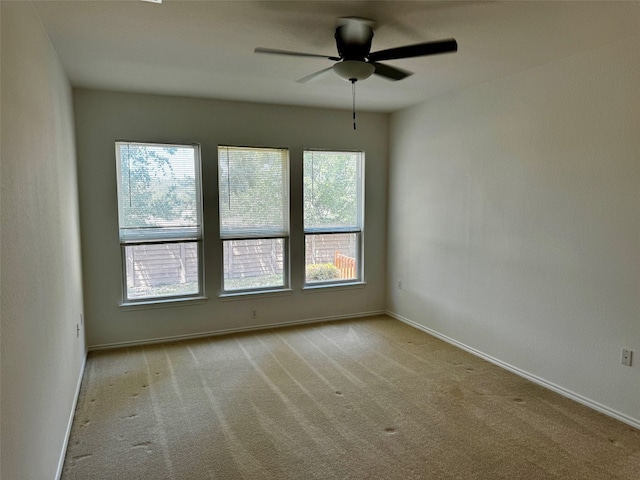 empty room featuring ceiling fan and light carpet