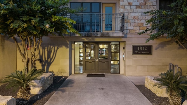 view of exterior entry featuring a balcony