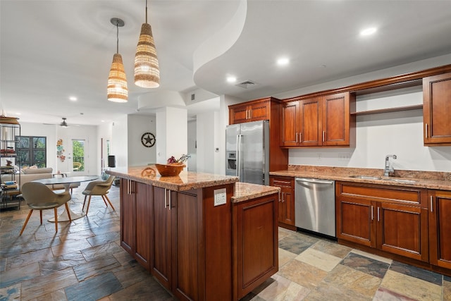 kitchen with light stone countertops, hanging light fixtures, stainless steel appliances, sink, and ceiling fan