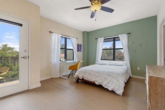 bedroom featuring access to exterior, ceiling fan, and multiple windows