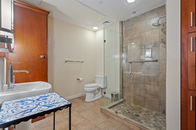 bathroom with walk in shower, toilet, sink, and tile patterned floors