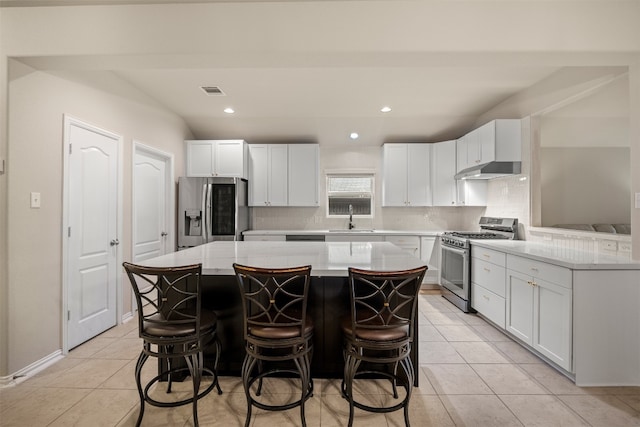 kitchen featuring a center island, white cabinets, stainless steel appliances, and light tile patterned floors