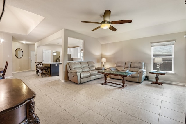 living room featuring ceiling fan, light tile patterned flooring, and vaulted ceiling