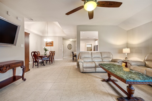 tiled living room with ceiling fan with notable chandelier and lofted ceiling