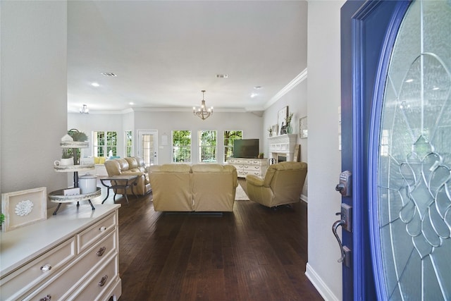 living room with dark hardwood / wood-style floors, crown molding, and a chandelier