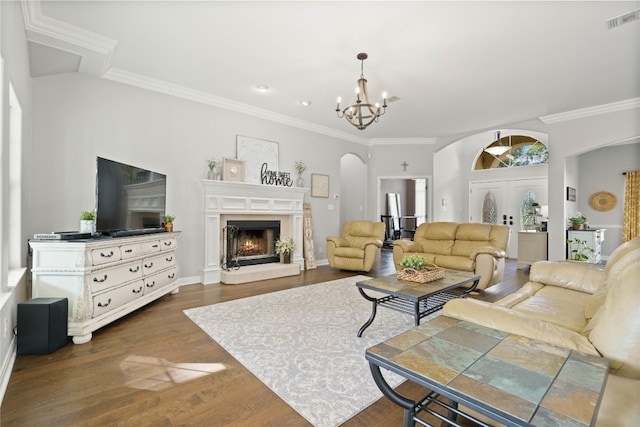 living room with a notable chandelier, ornamental molding, and dark wood-type flooring