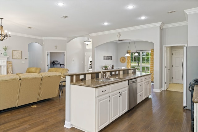 kitchen with appliances with stainless steel finishes, a chandelier, white cabinets, sink, and dark wood-type flooring