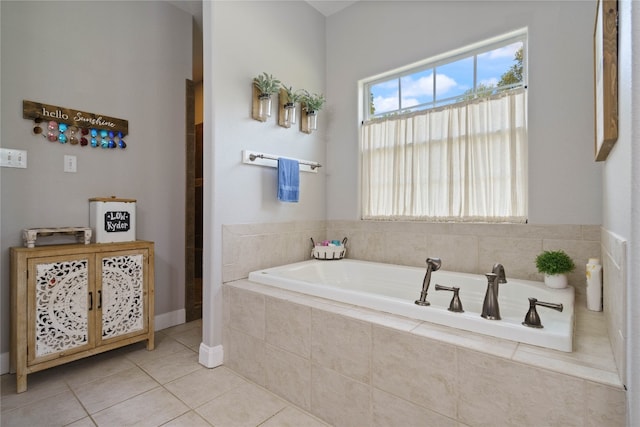 bathroom with tile patterned floors and a relaxing tiled tub