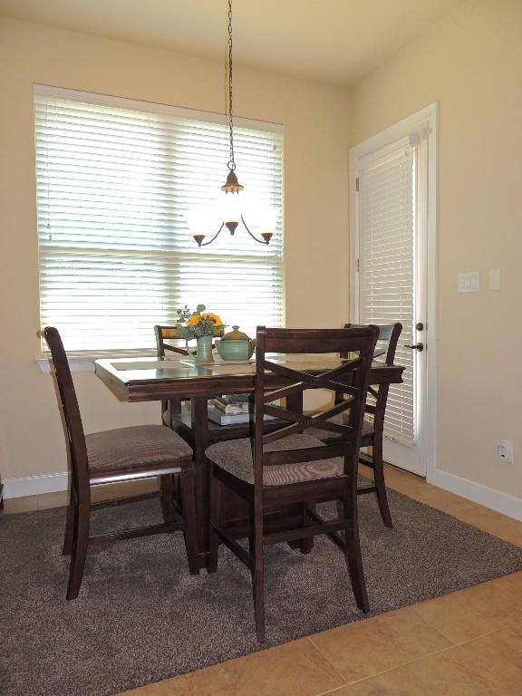 tiled dining space with a chandelier