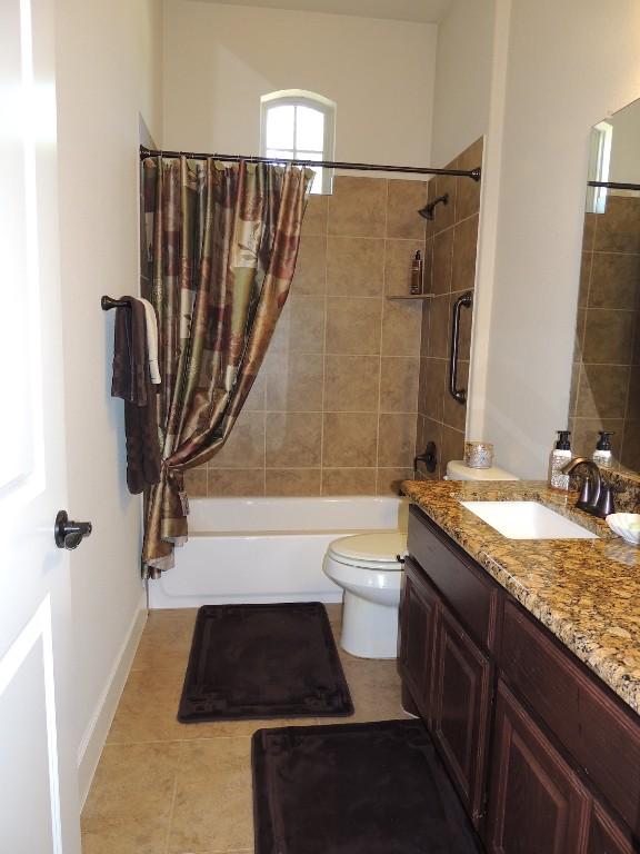 bathroom with shower / bath combination, vanity, toilet, and tile patterned floors