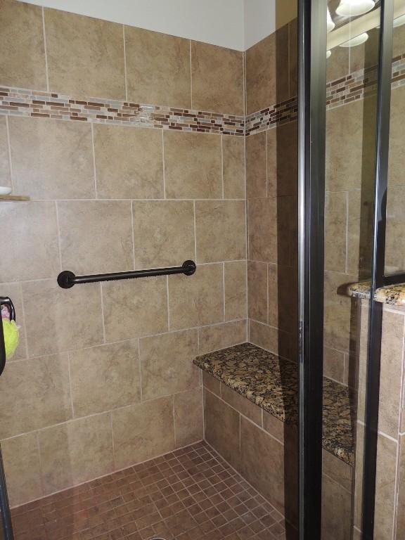 bathroom featuring a shower with door