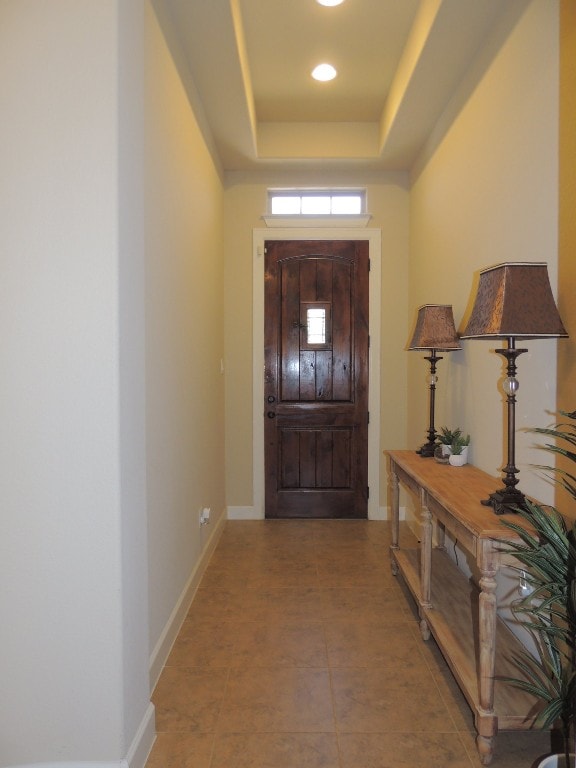 tiled foyer with a tray ceiling