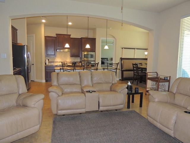 living room with light tile patterned floors, arched walkways, and recessed lighting