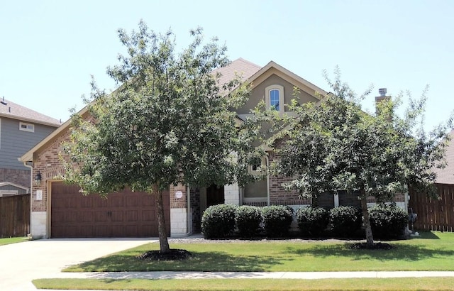 view of property hidden behind natural elements featuring brick siding, fence, driveway, and a front lawn