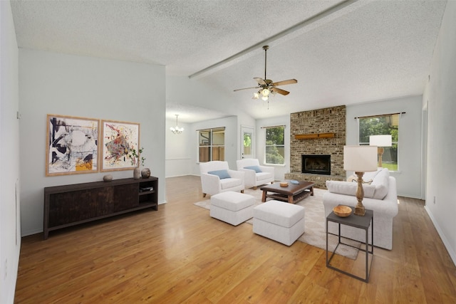 living room featuring a wealth of natural light, wood-type flooring, lofted ceiling with beams, and a brick fireplace