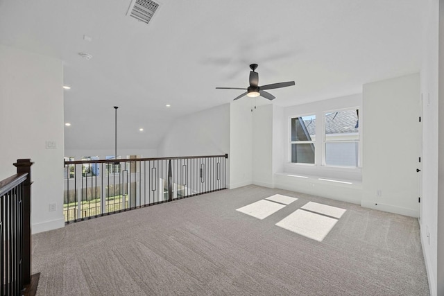 carpeted spare room featuring ceiling fan and lofted ceiling