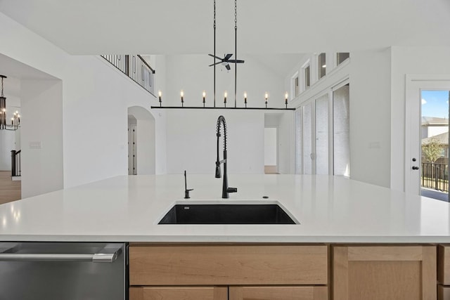 kitchen featuring an inviting chandelier, light brown cabinets, a kitchen island with sink, pendant lighting, and sink