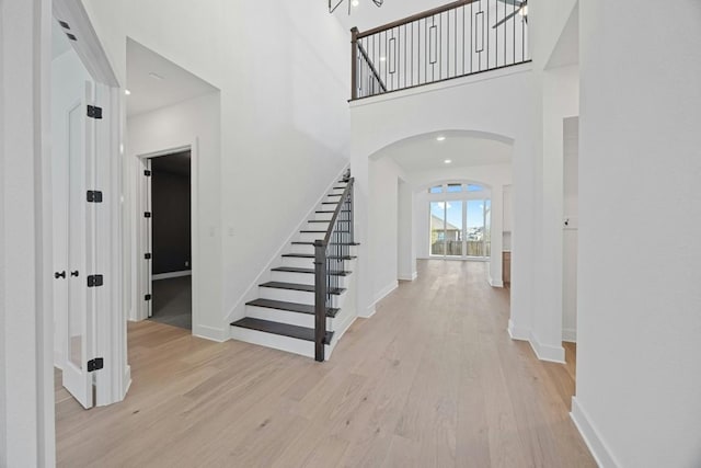 foyer featuring a towering ceiling and light hardwood / wood-style flooring