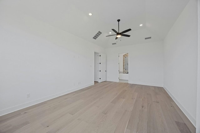 unfurnished room with a high ceiling, ceiling fan, and light wood-type flooring