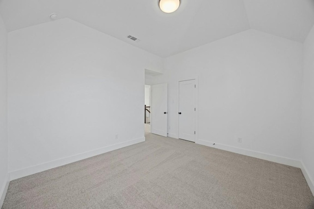 spare room with lofted ceiling and light carpet