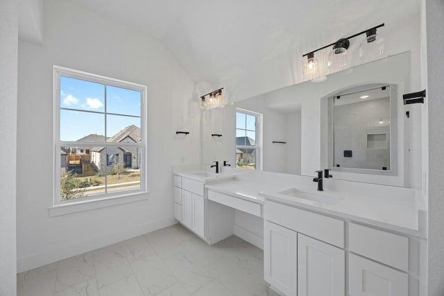 bathroom featuring vanity, vaulted ceiling, and a shower