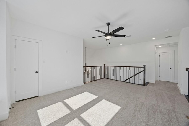 empty room featuring ceiling fan and light carpet