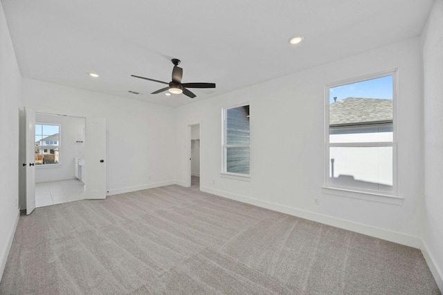 empty room featuring ceiling fan and light colored carpet