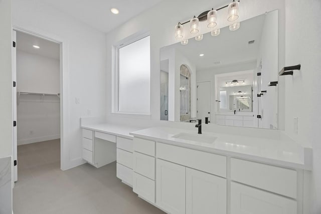 bathroom with vanity, a shower with door, and a healthy amount of sunlight