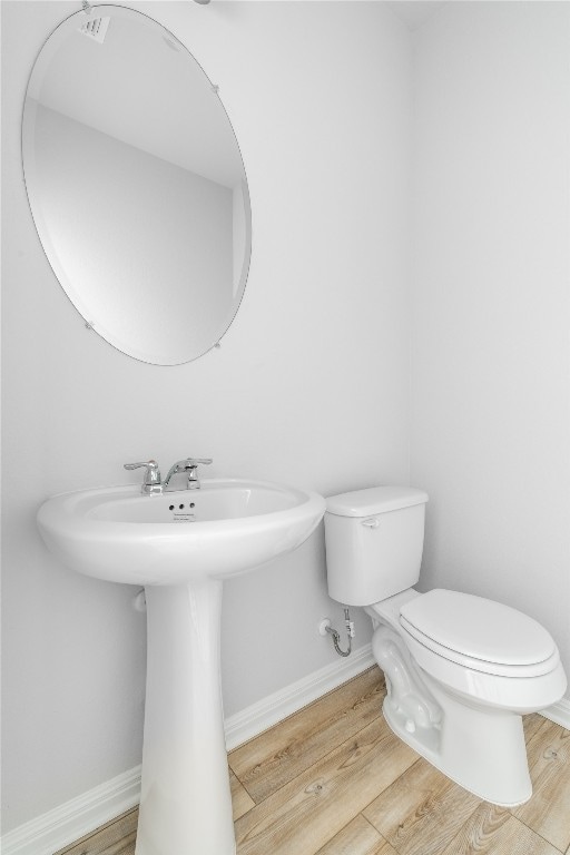 bathroom featuring hardwood / wood-style floors and toilet