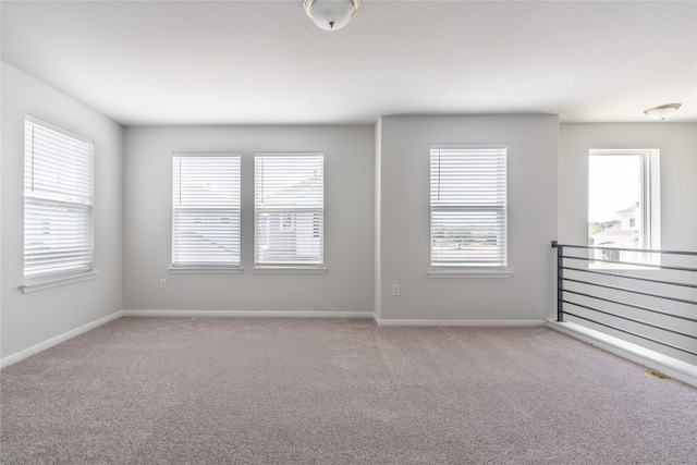 carpeted spare room featuring a wealth of natural light