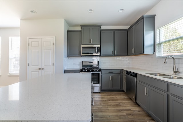 kitchen featuring appliances with stainless steel finishes, tasteful backsplash, dark hardwood / wood-style flooring, and a healthy amount of sunlight