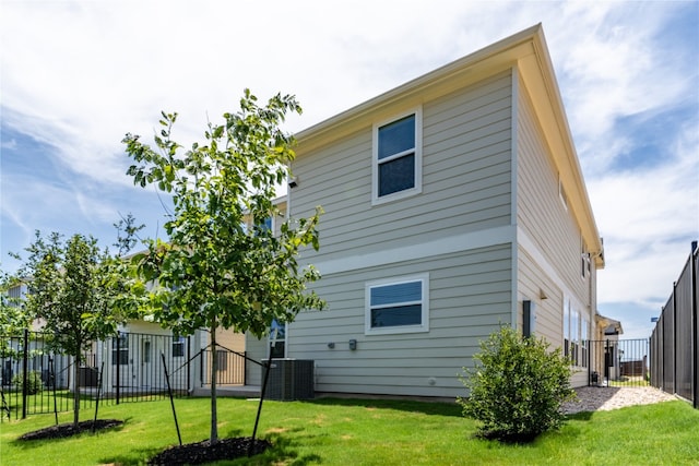 back of house featuring cooling unit and a lawn