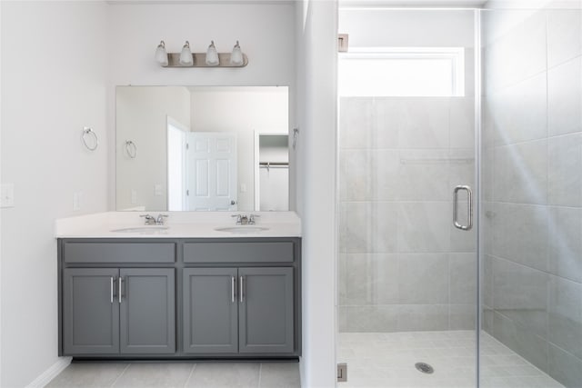 bathroom featuring dual bowl vanity, tile patterned floors, and a shower with shower door