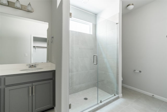 bathroom featuring a shower with door, tile patterned floors, and vanity