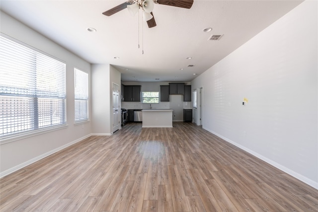 unfurnished living room featuring ceiling fan and light hardwood / wood-style floors