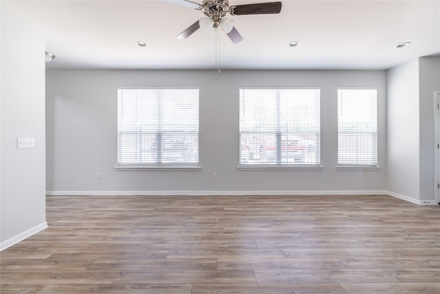 unfurnished room with ceiling fan, hardwood / wood-style flooring, and a wealth of natural light