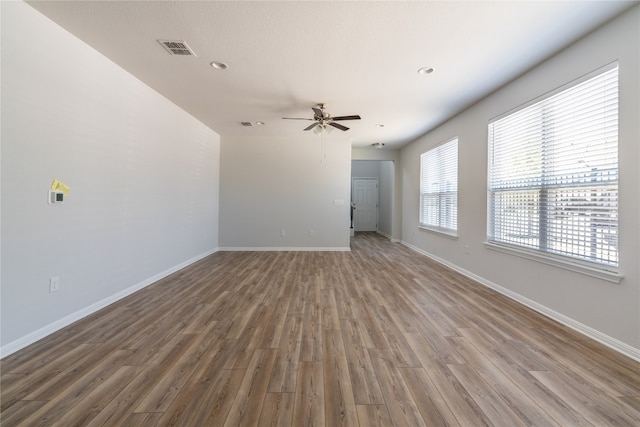 empty room with ceiling fan and hardwood / wood-style flooring