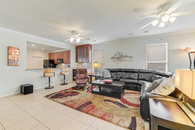 living room with light tile patterned flooring, ornamental molding, and ceiling fan