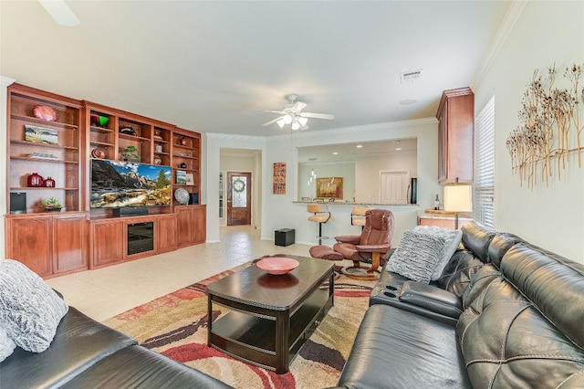 tiled living room with ceiling fan and ornamental molding