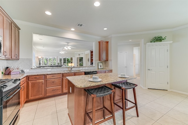 kitchen with kitchen peninsula, black range with gas cooktop, a breakfast bar, and decorative backsplash