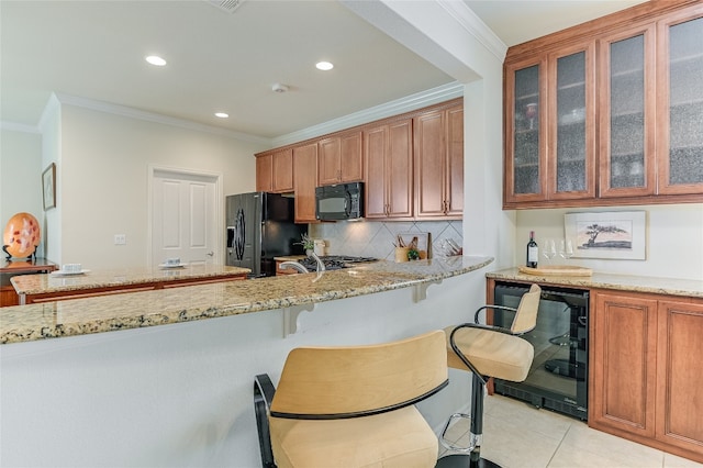 kitchen with tasteful backsplash, light tile patterned floors, light stone countertops, ornamental molding, and black appliances