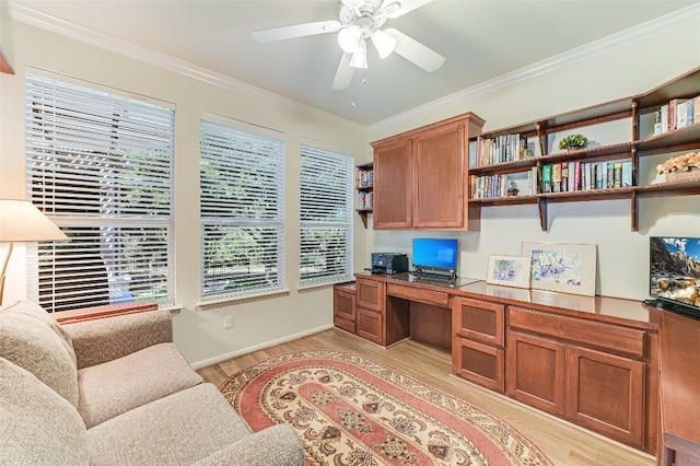 office space featuring light wood-type flooring, crown molding, ceiling fan, and built in desk