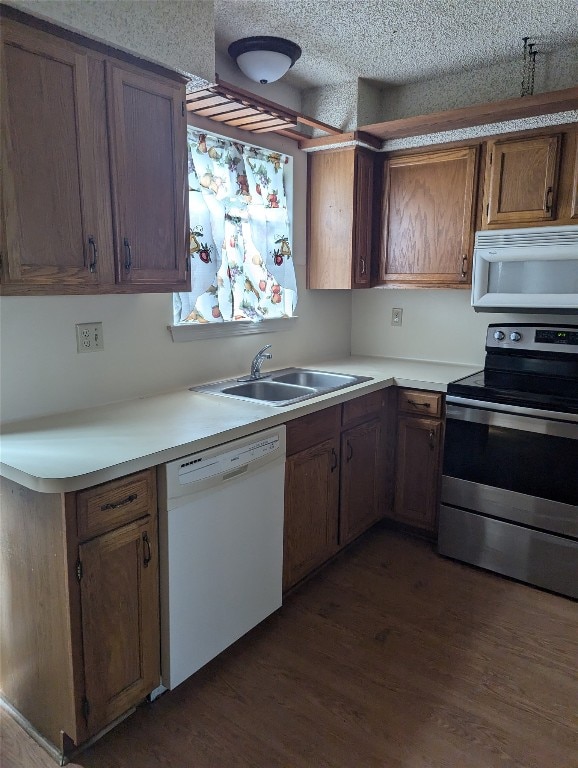 kitchen featuring a textured ceiling, dark hardwood / wood-style floors, white appliances, and sink