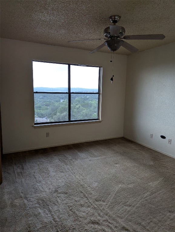 spare room with ceiling fan, a textured ceiling, and carpet floors