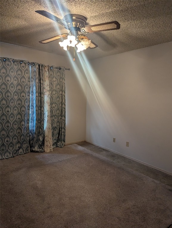 spare room featuring ceiling fan, a textured ceiling, and carpet flooring